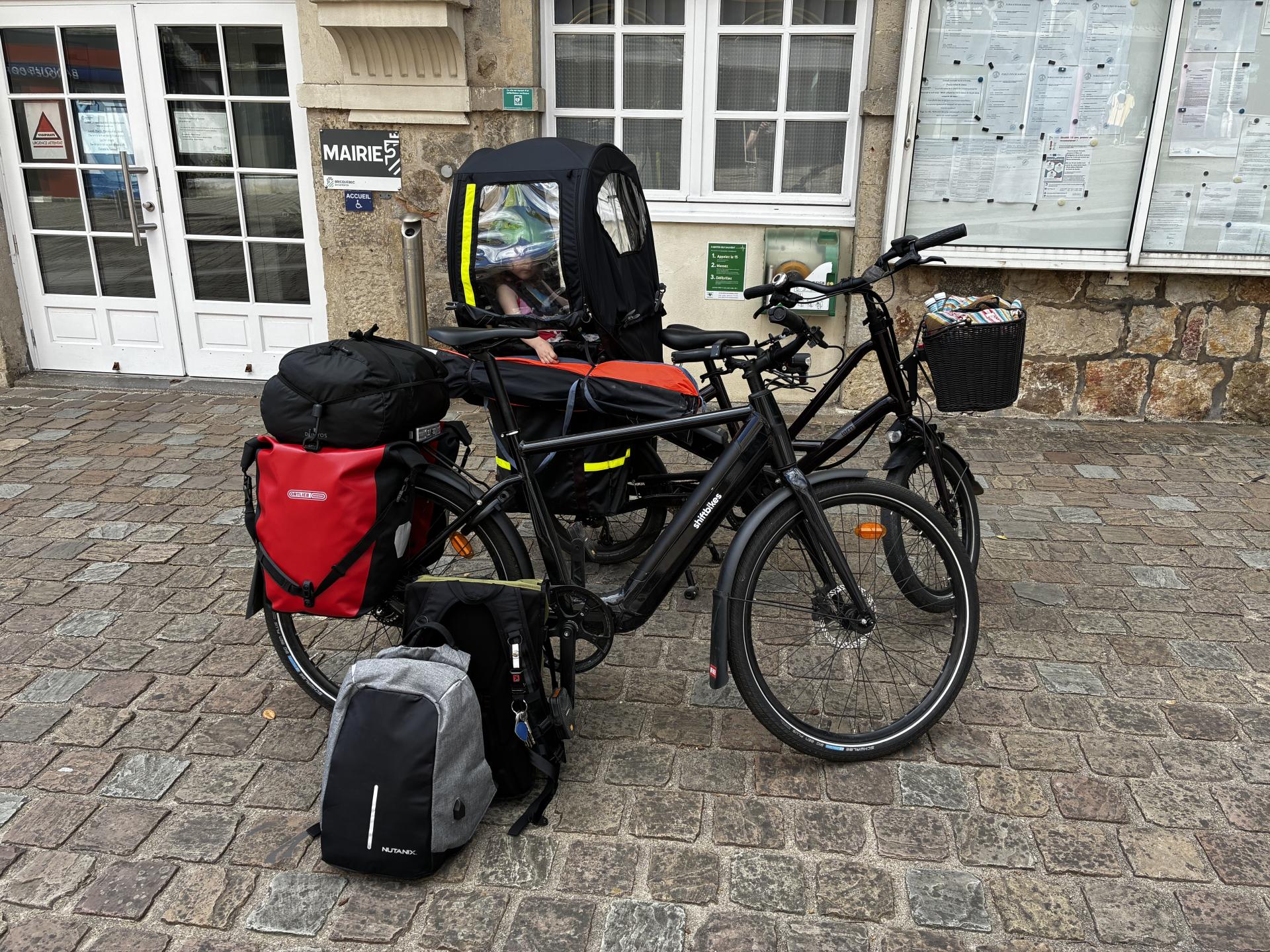 Vélos électriques en voyage garés devant la mairie de Bricquebec-en-Cotentin